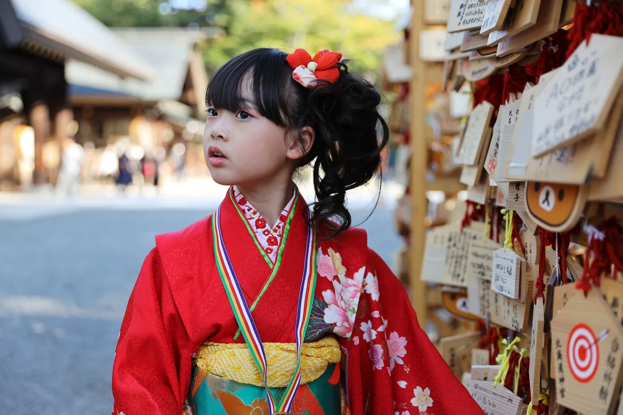 A young girl in a red formal kimono at a shrine for the Shichi-Go-San rite in November