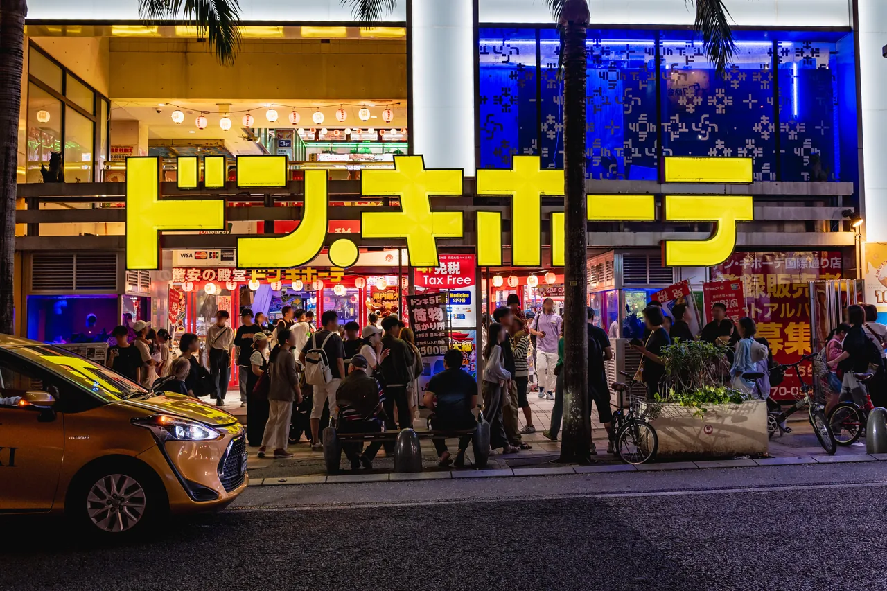 A Don Quijote store at night on Kokusai-dori in Naha, with bright neon signage and Tax-Free signs
