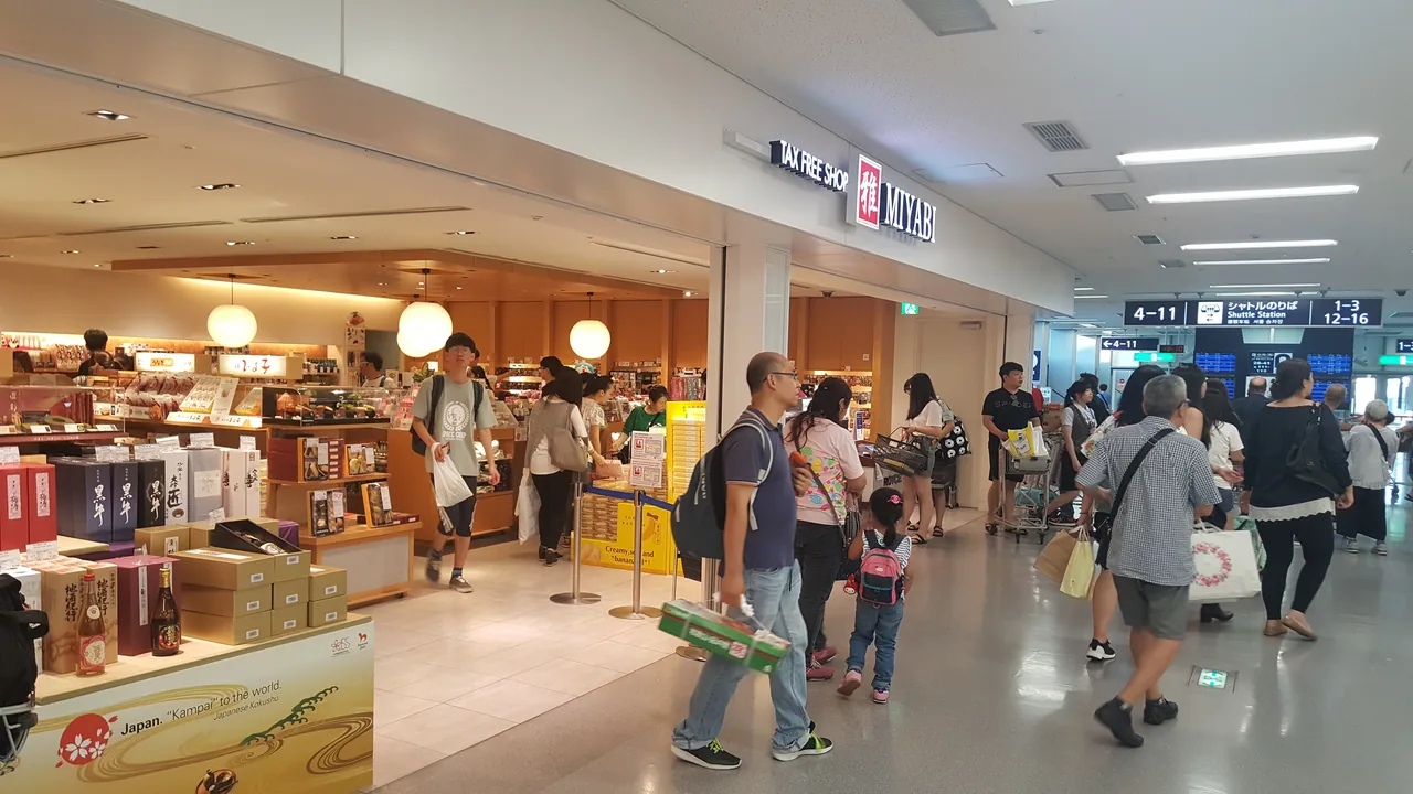 A tax-free shop inside Kansai International Airport with travellers carrying shopping bags
