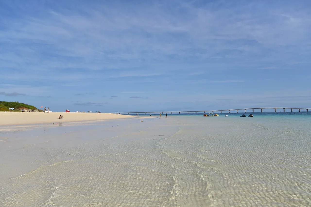 Yonaha Maehama: seven kilometres of white sand and calm shallows, with the Kurima bridge arcing away in the distance.