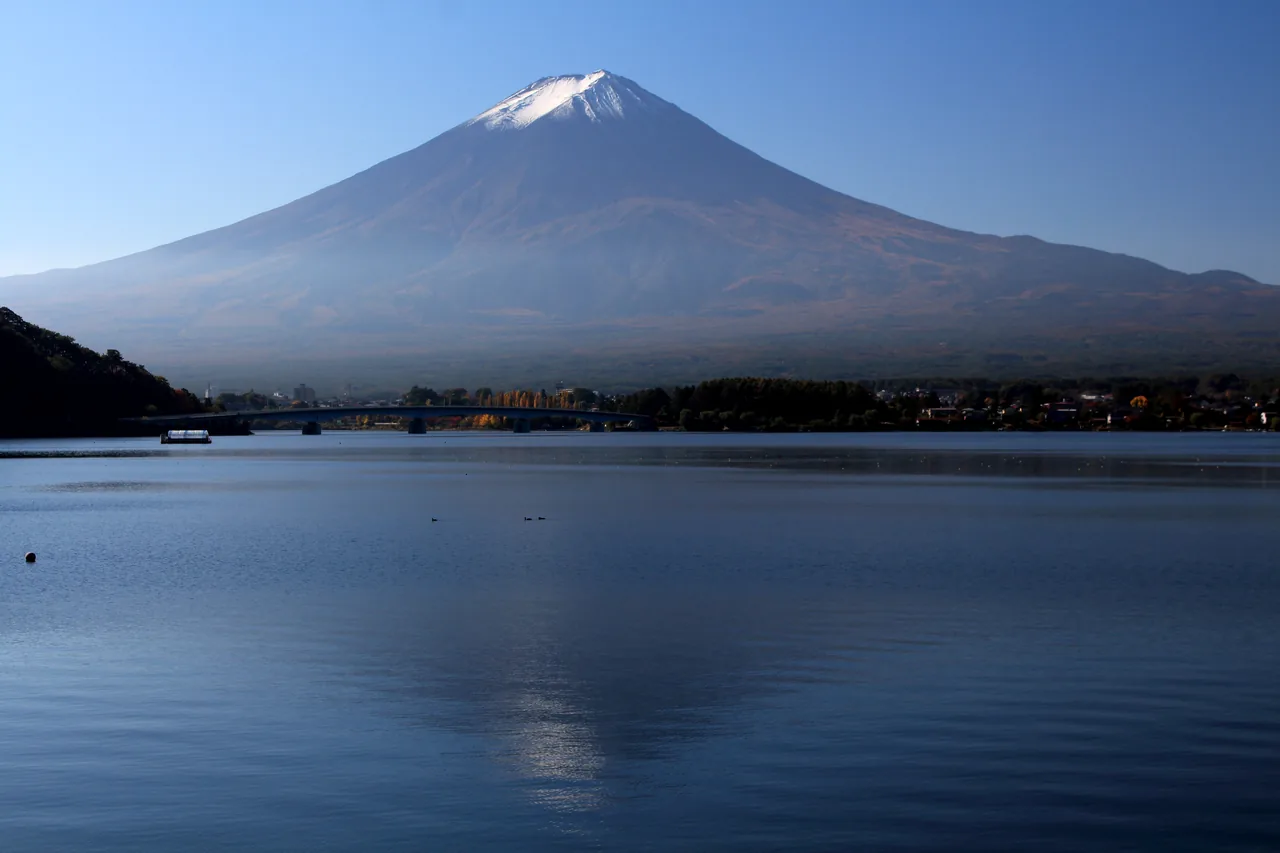 Mt Fuji rising snow-capped behind Lake Kawaguchi at dawn
