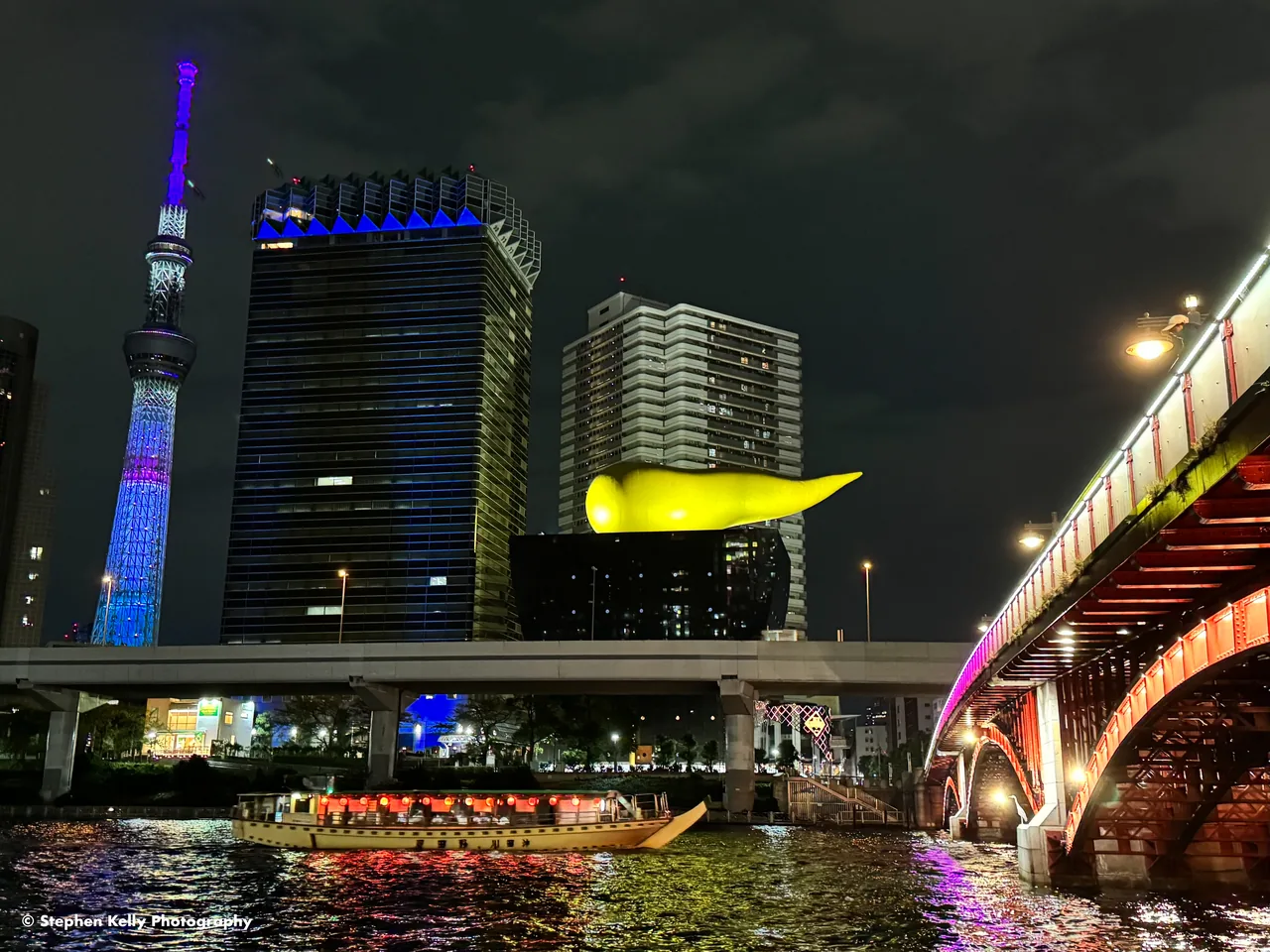 A sightseeing boat on the Sumida River with Tokyo Skytree and Asakusa's Asahi Beer Hall in the background A sightseeing boat on the Sumida River with Tokyo Skytree and Asakusa's Asahi Beer Hall in the background