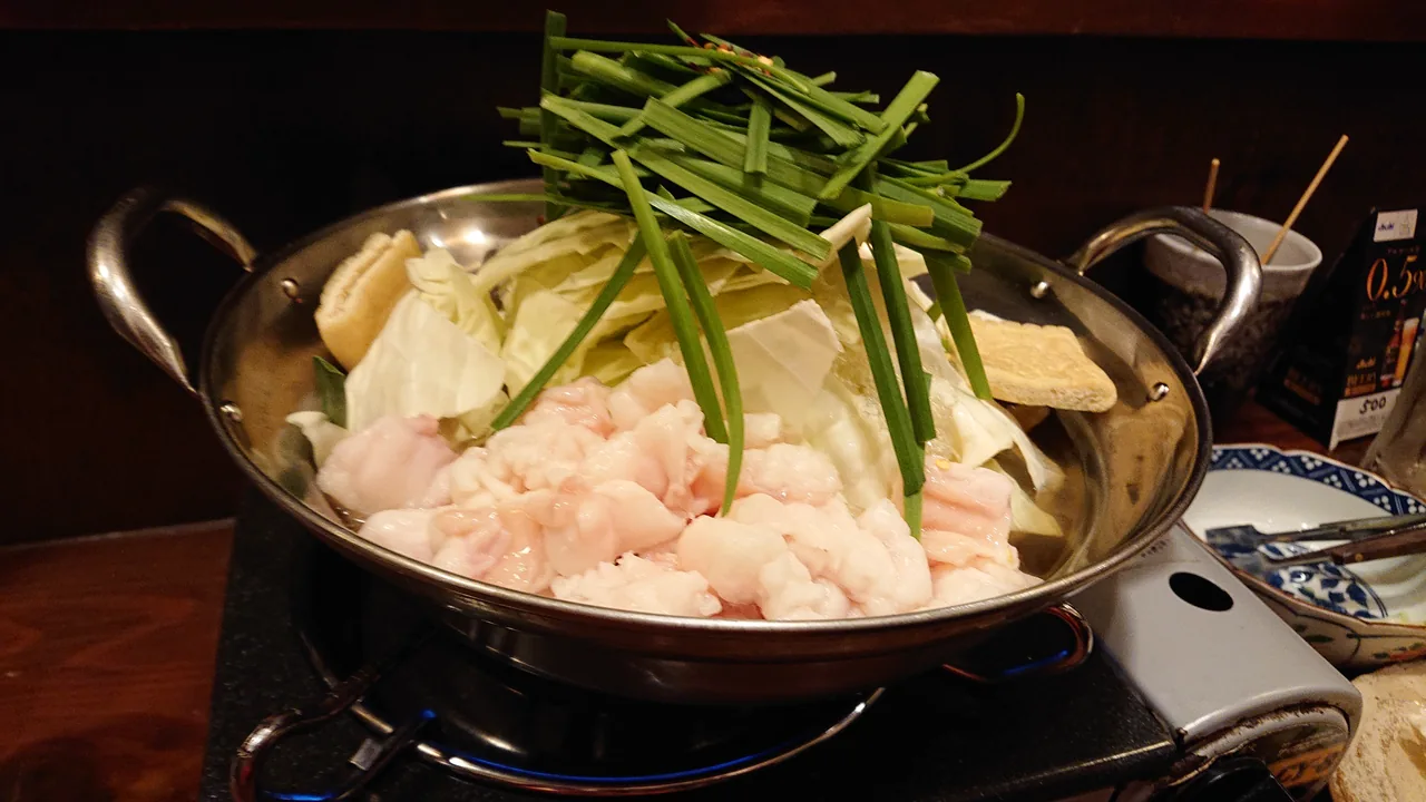 A motsunabe offal hotpot with cabbage and chives simmering at a Fukuoka izakaya