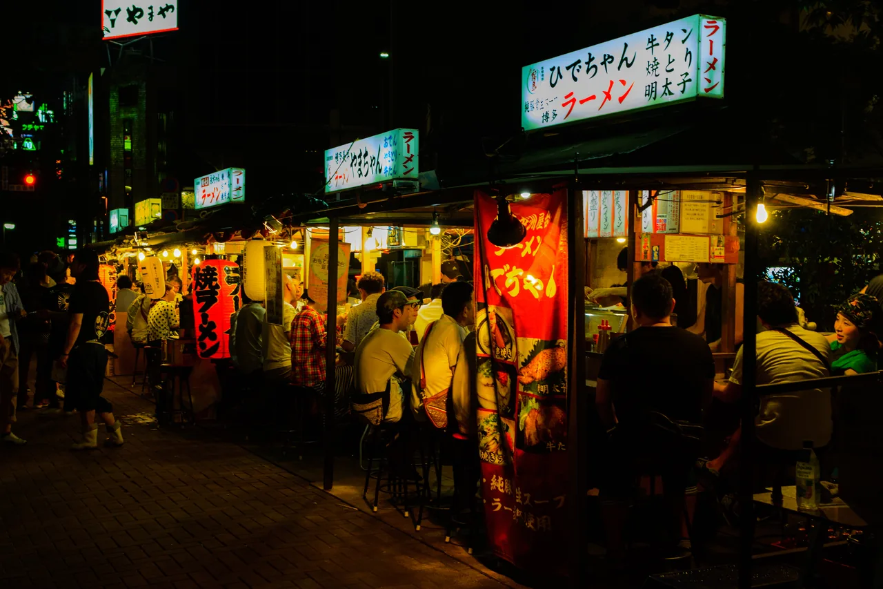 Nakasu yatai food stalls lit up along the river in Fukuoka after dark
