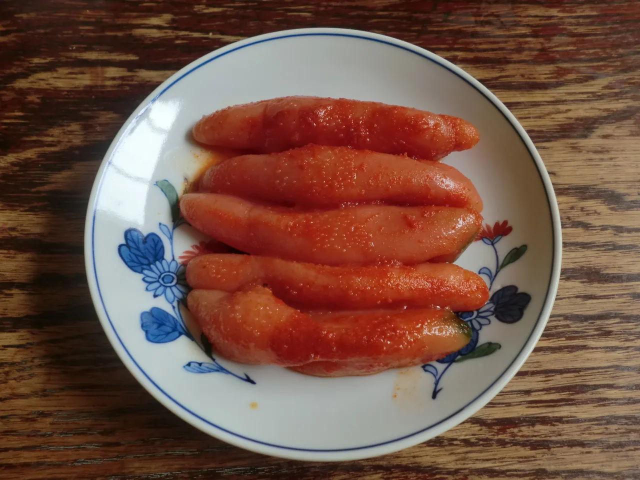 A plate of whole karashi mentaiko, glossy red spicy pollock roe sacs