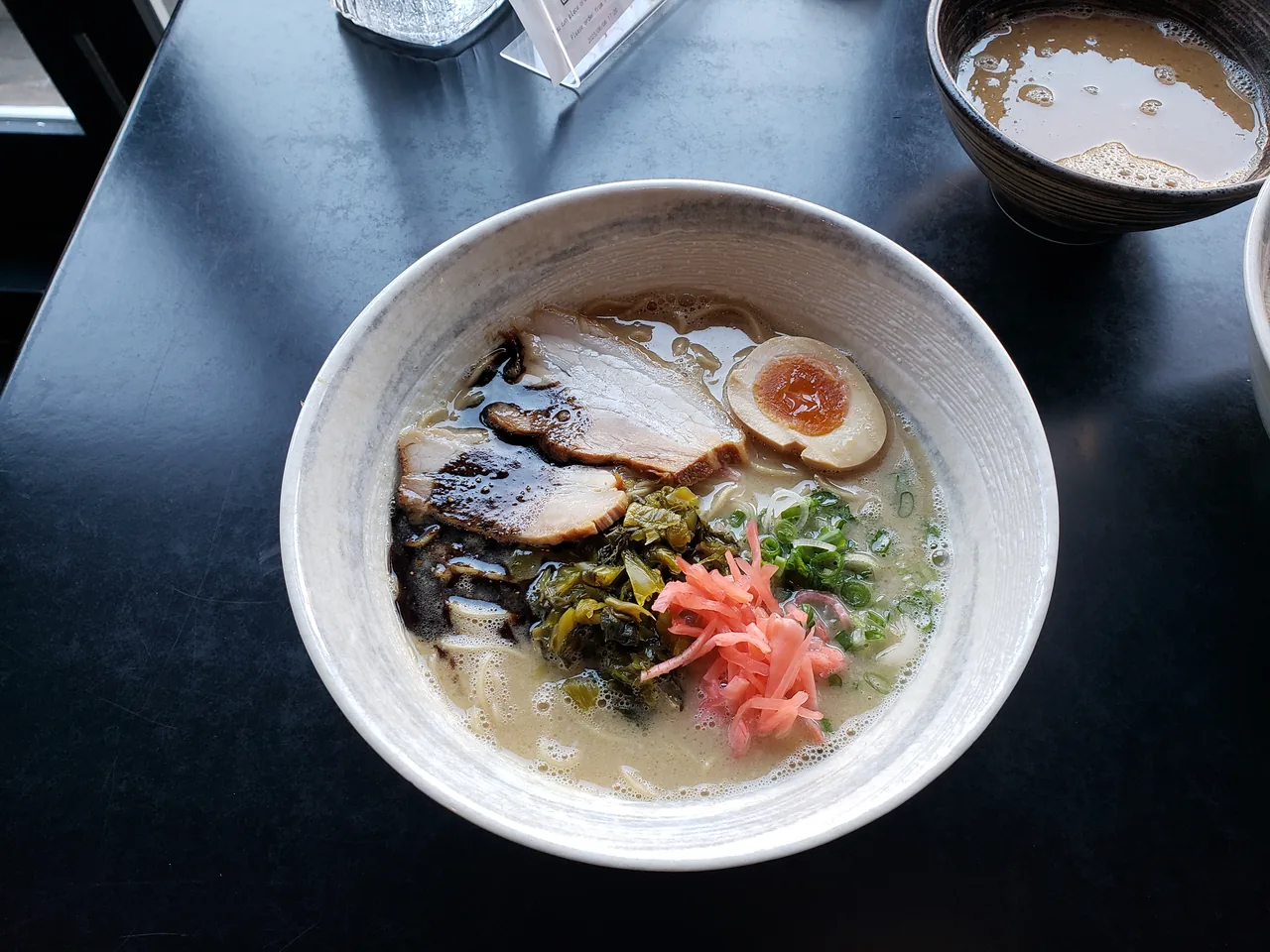 A bowl of Hakata tonkotsu ramen with chashu pork, egg and pickled ginger A bowl of Hakata tonkotsu ramen with chashu pork, egg and pickled ginger