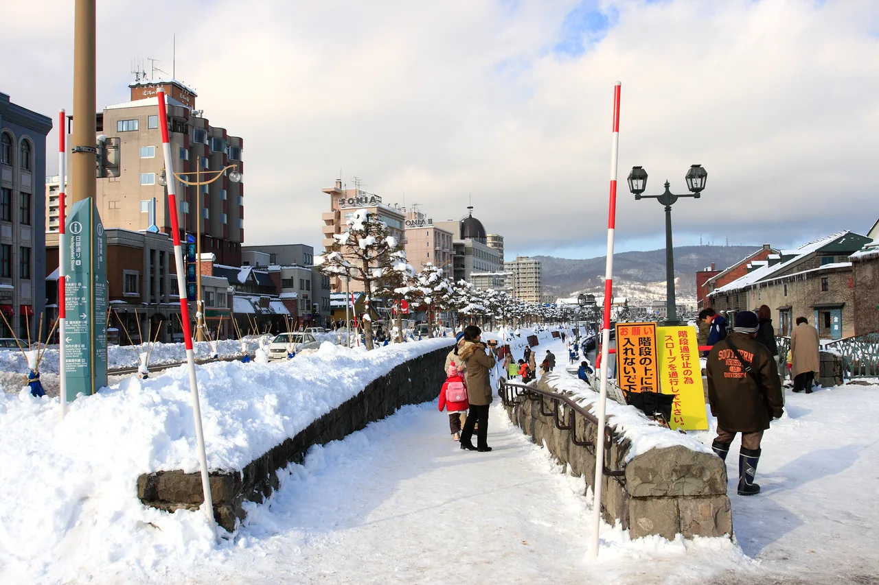 A snow-covered street with red-and-white snow poles in Otaru, Hokkaido