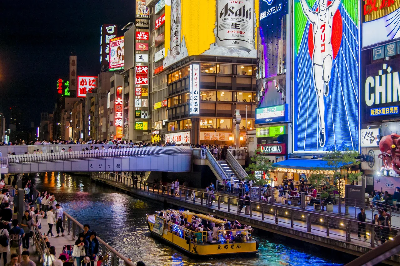 The Dotonbori canal at night with the Glico running man sign in Osaka The Dotonbori canal at night with the Glico running man sign in Osaka