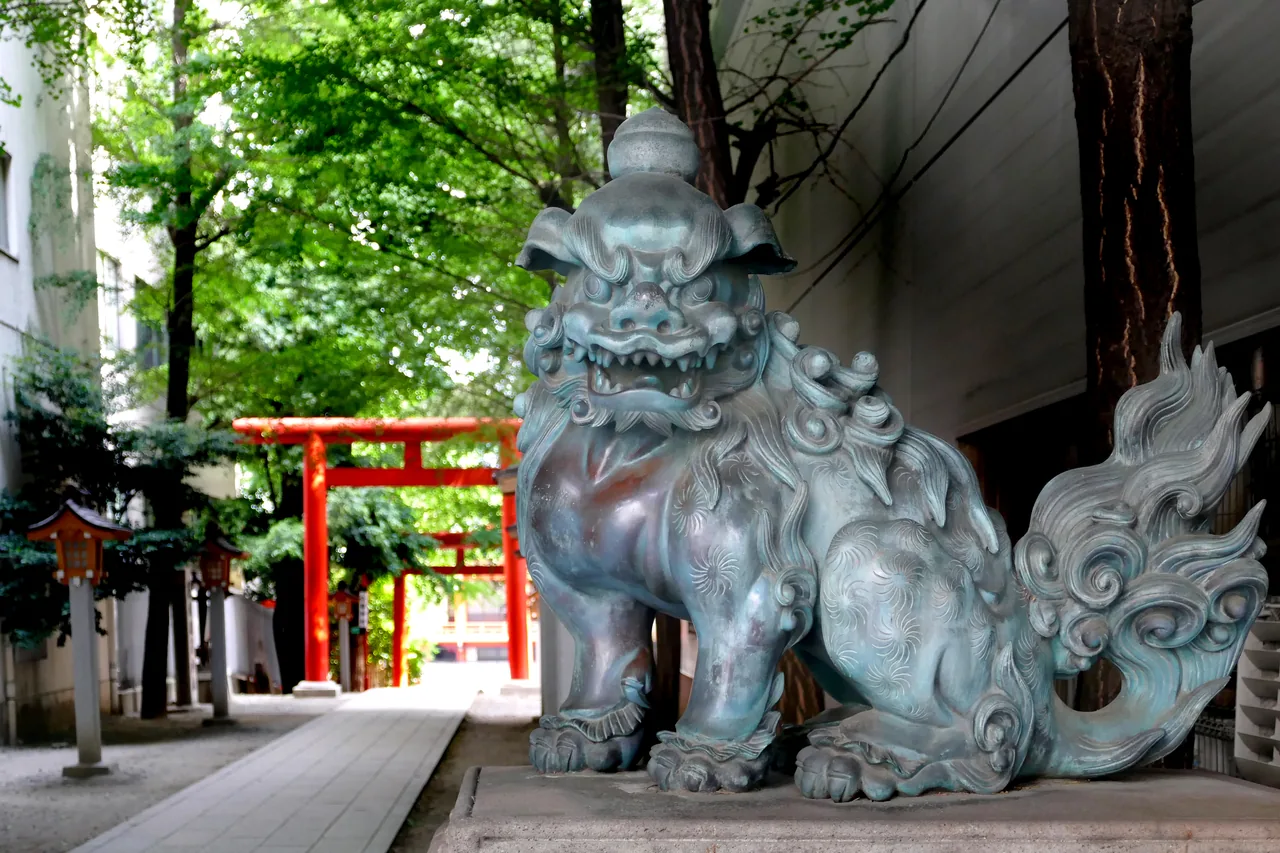 A guardian komainu statue and torii gate at Hanazono Shrine in Shinjuku