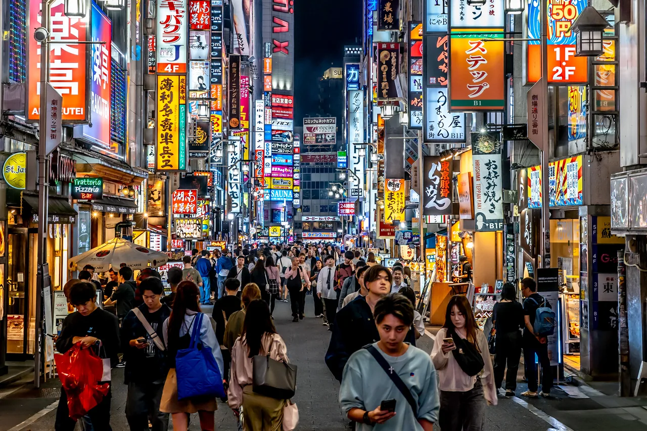A neon-lit street in Shinjuku, Tokyo at night