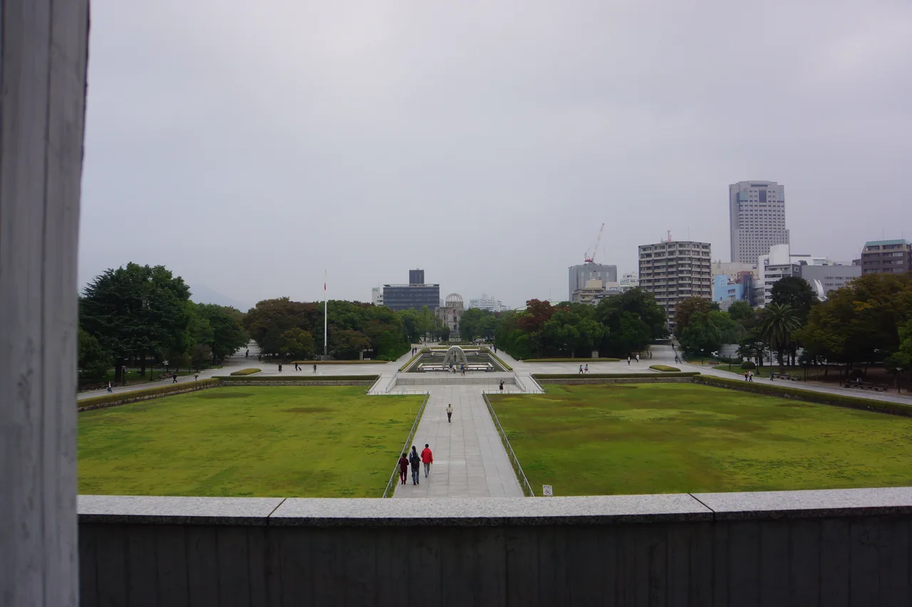 The lawn and central axis of Hiroshima Peace Memorial Park with the city behind it