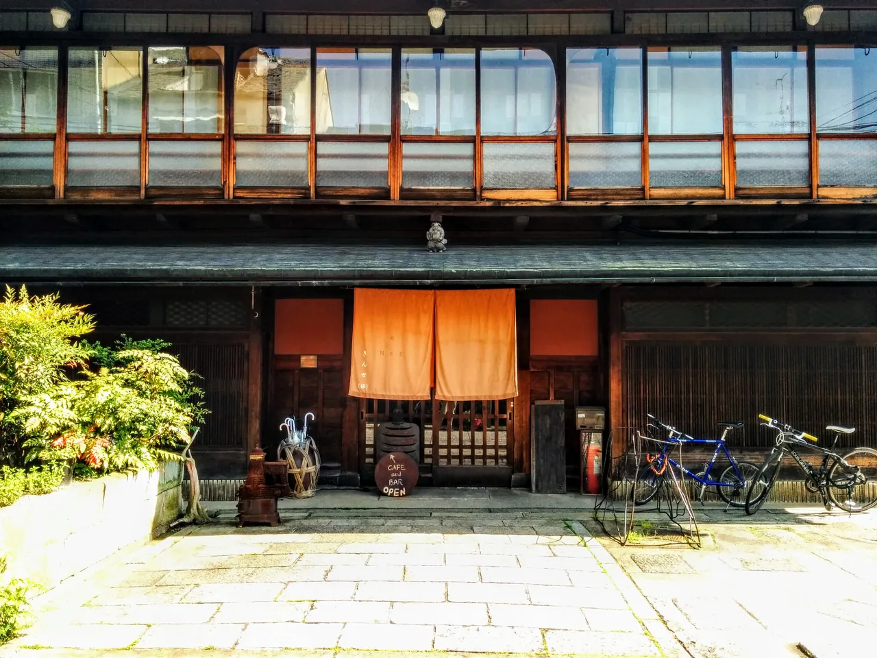 The wooden street frontage of a machiya inn in Kyoto, with a noren curtain over the entrance The wooden street frontage of a machiya inn in Kyoto, with a noren curtain over the entrance
