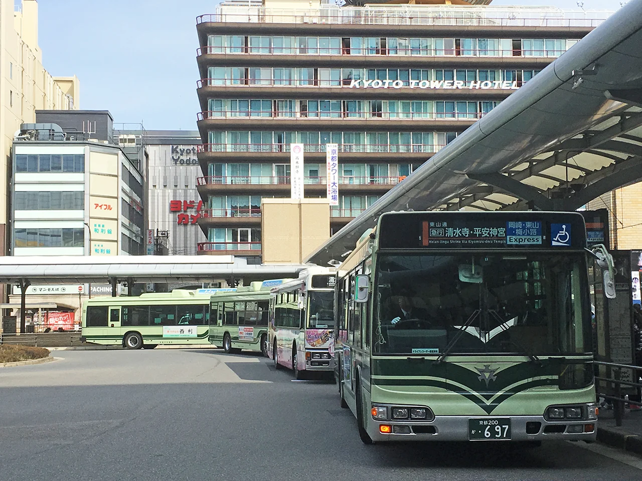 Kyoto city buses lined up at the Kyoto Station bus terminal, the nearest one showing Kiyomizu-dera and Heian Jingu on its destination board