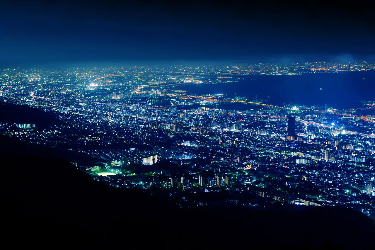 The lights of Kobe and Osaka Bay spread out below the Kikuseidai terrace on Mount Maya after dark