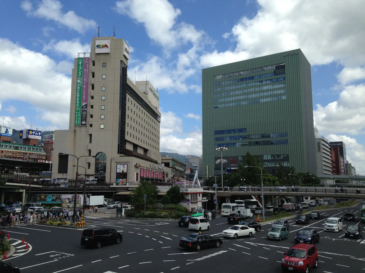 The crossing outside Sannomiya station with office towers on both sides and traffic waiting at the lights