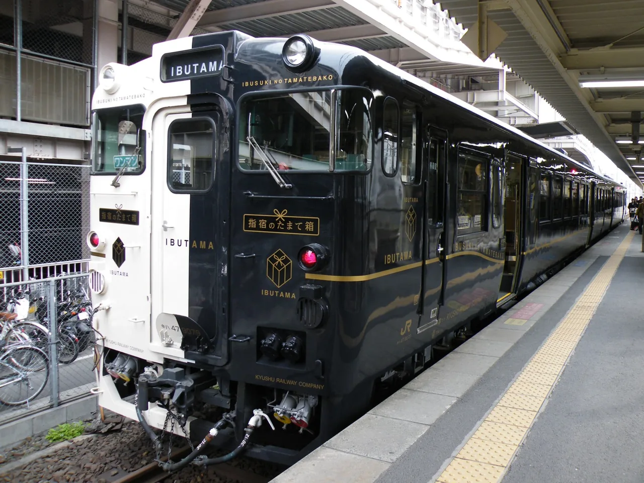 The black and white Ibusuki no Tamatebako railcar standing at a platform