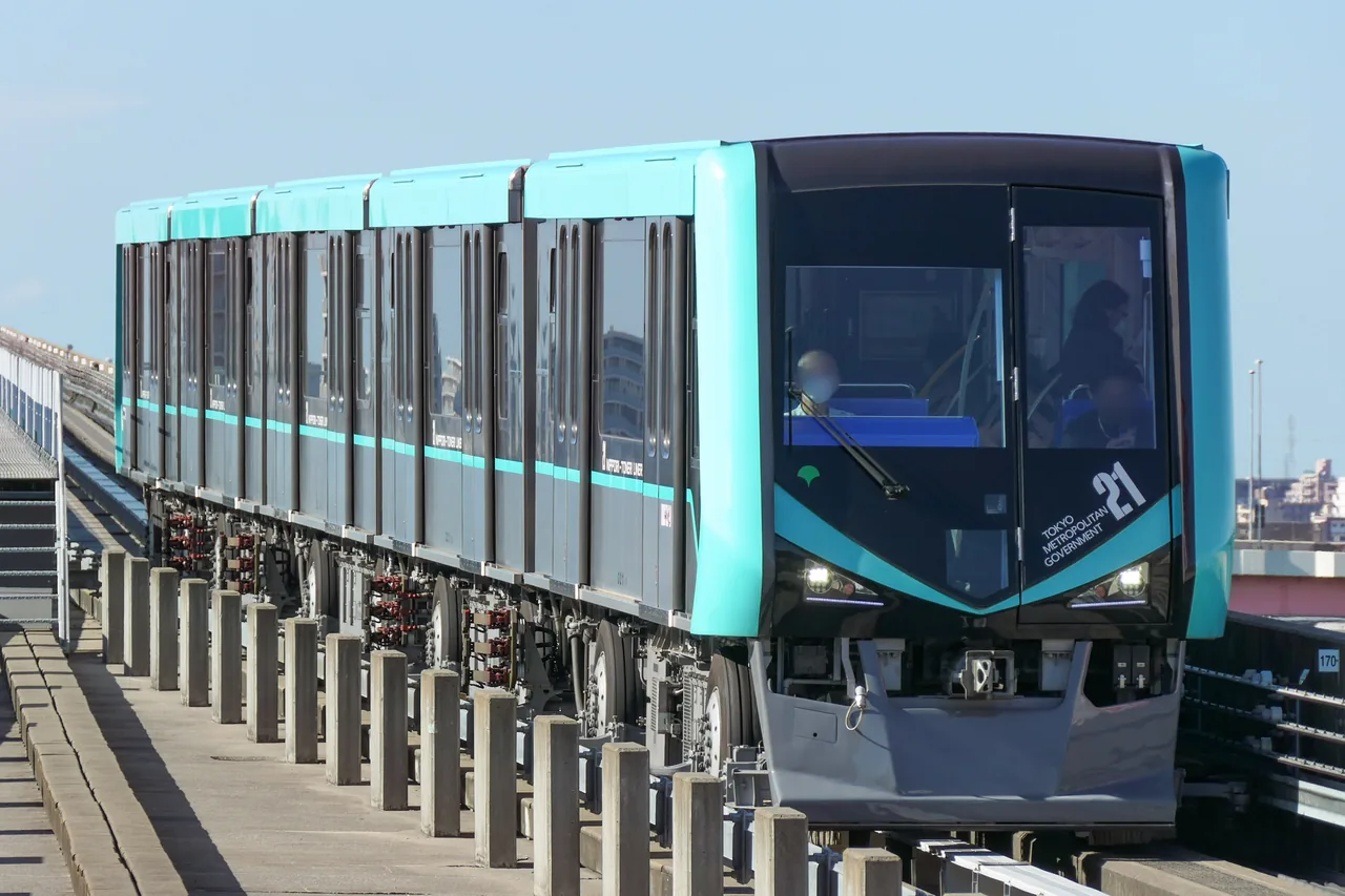 A teal Nippori-Toneri Liner train on its elevated guideway