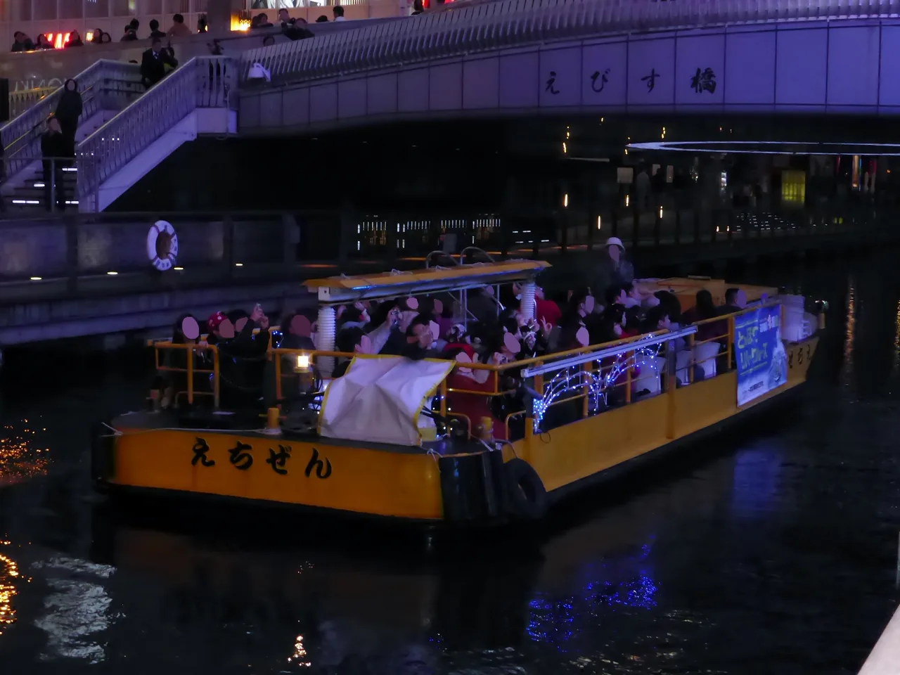 A Tombori River Cruise boat passing under Ebisubashi bridge on the Dotonbori canal