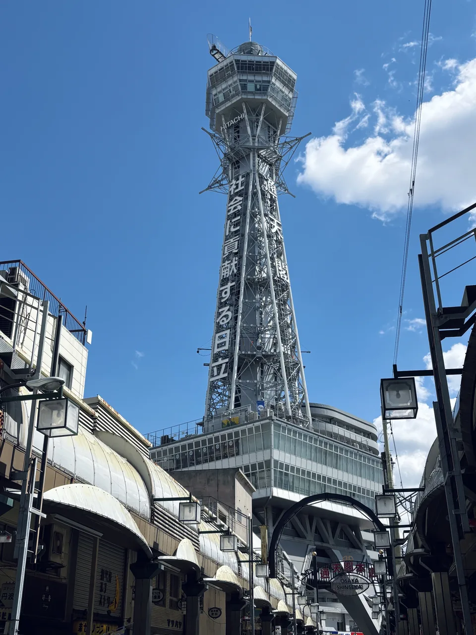 The Tsutenkaku tower rising above the Shinsekai streets under a blue sky