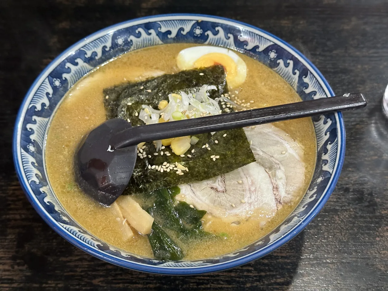 A bowl of Sapporo miso ramen topped with nori, chashu pork, a soft egg and bean sprouts