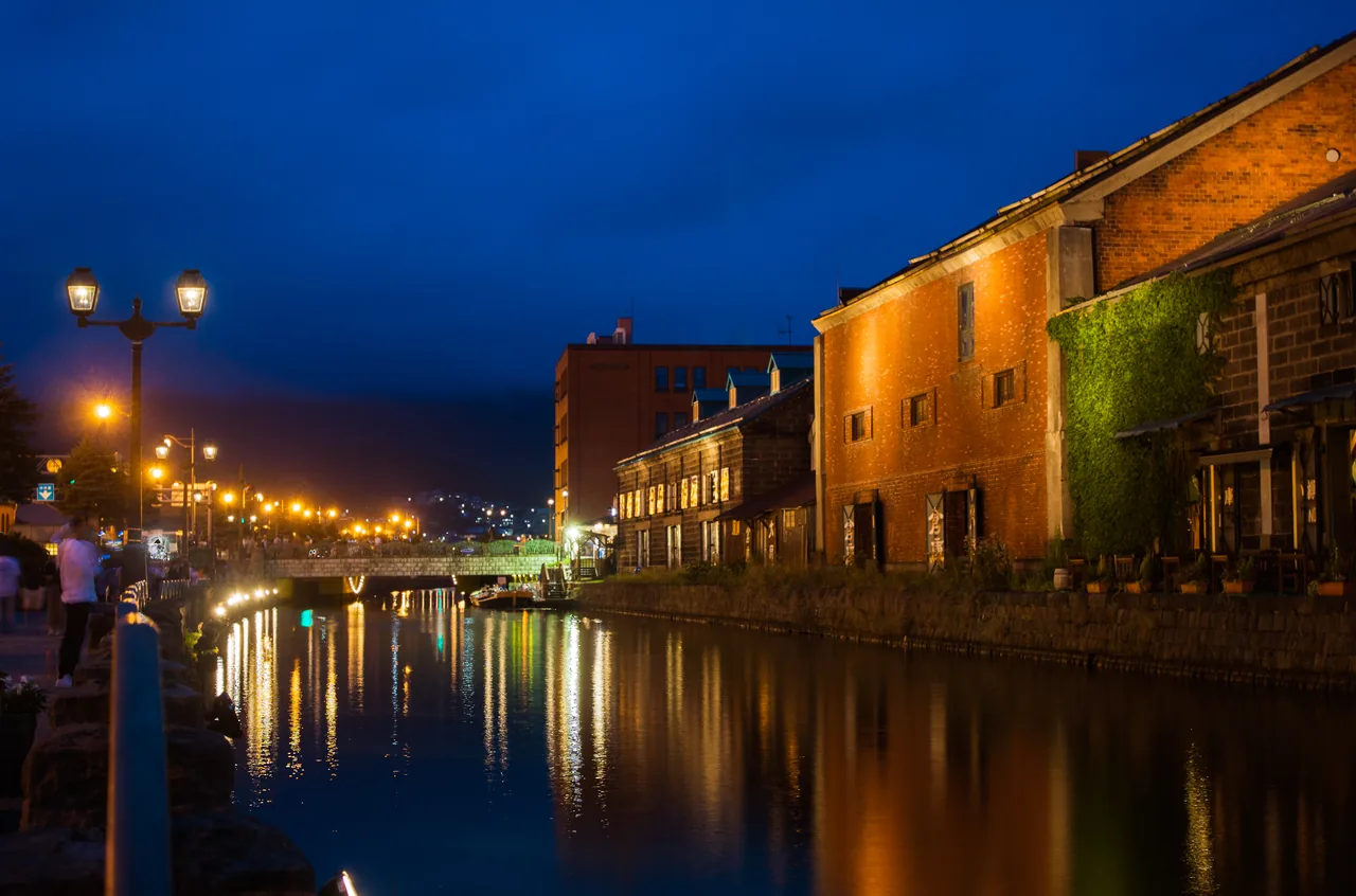 Gas lamps and brick warehouses reflected in the Otaru Canal at dusk