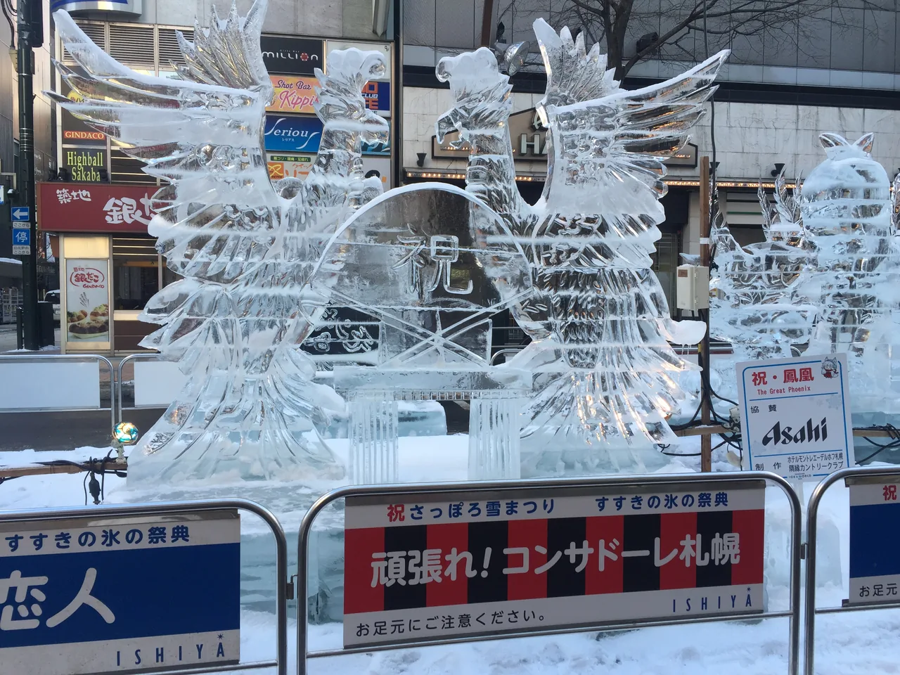 A large phoenix carved from clear ice standing on the street at the Susukino site