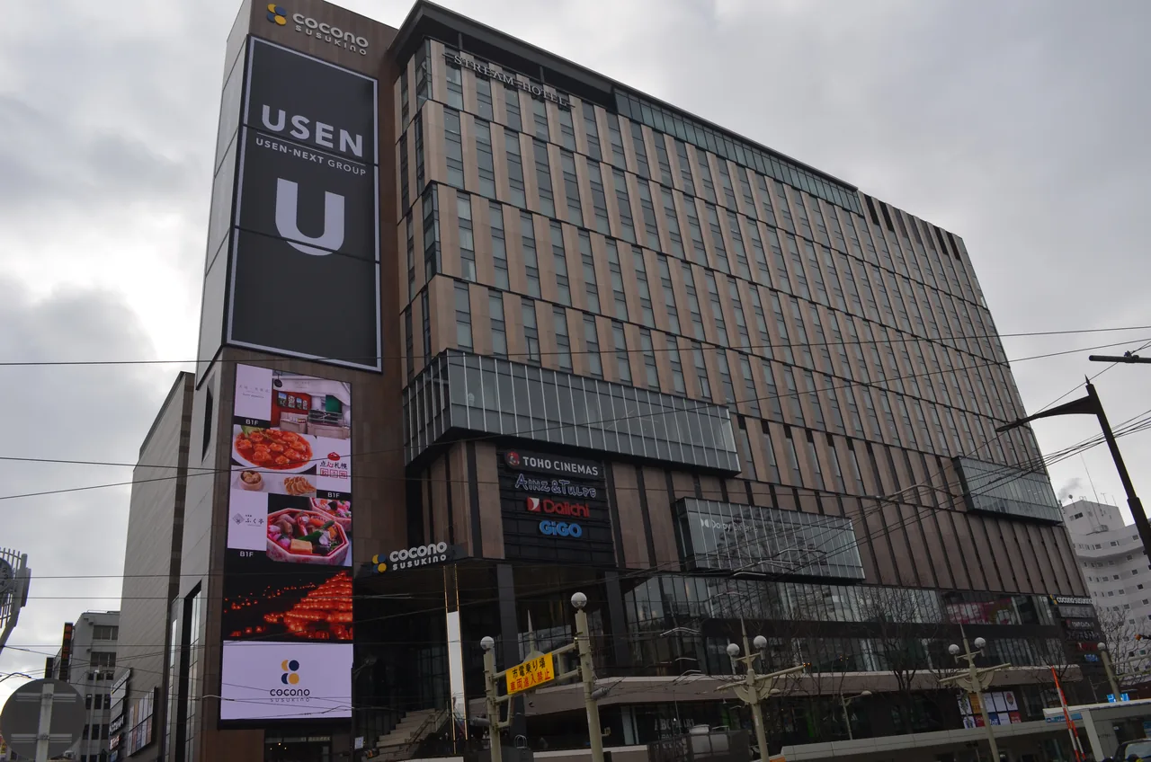 The Susukino district in Sapporo, with signage on the building facades along a main intersection.