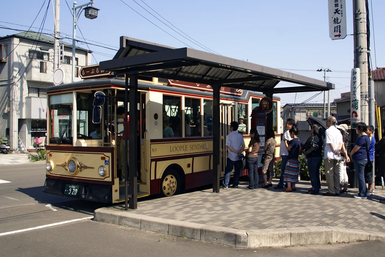 The retro styled Loople Sendai loop bus stopped at a kerbside stop with passengers waiting to board