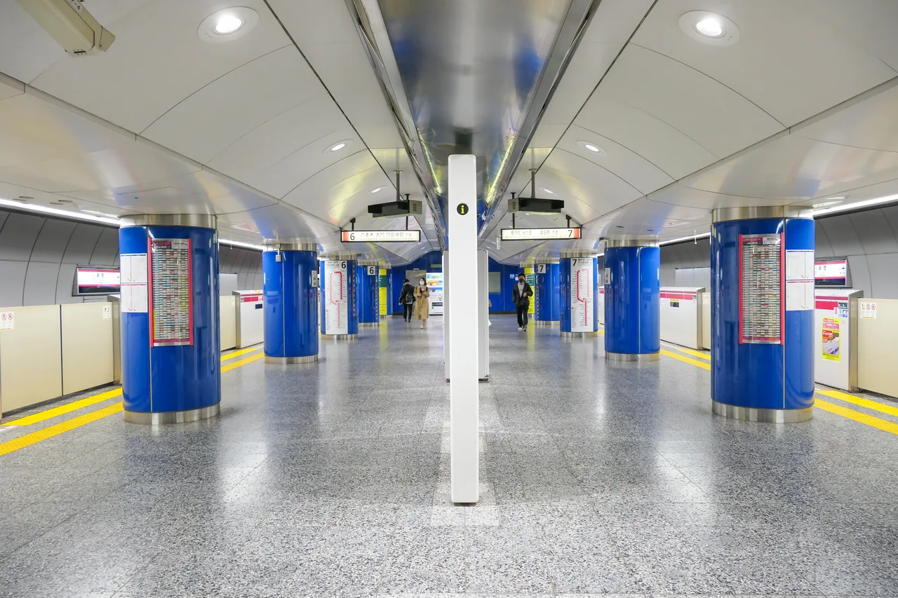 An empty platform on the Toei Oedo Line at Shinjuku, with blue-clad pillars running down the middle