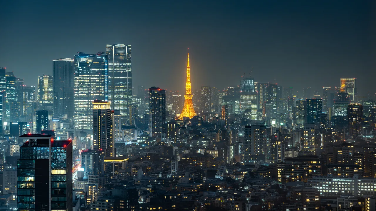 Tokyo Tower lit orange at night above the surrounding office towers of Minato Tokyo Tower lit orange at night above the surrounding office towers of Minato