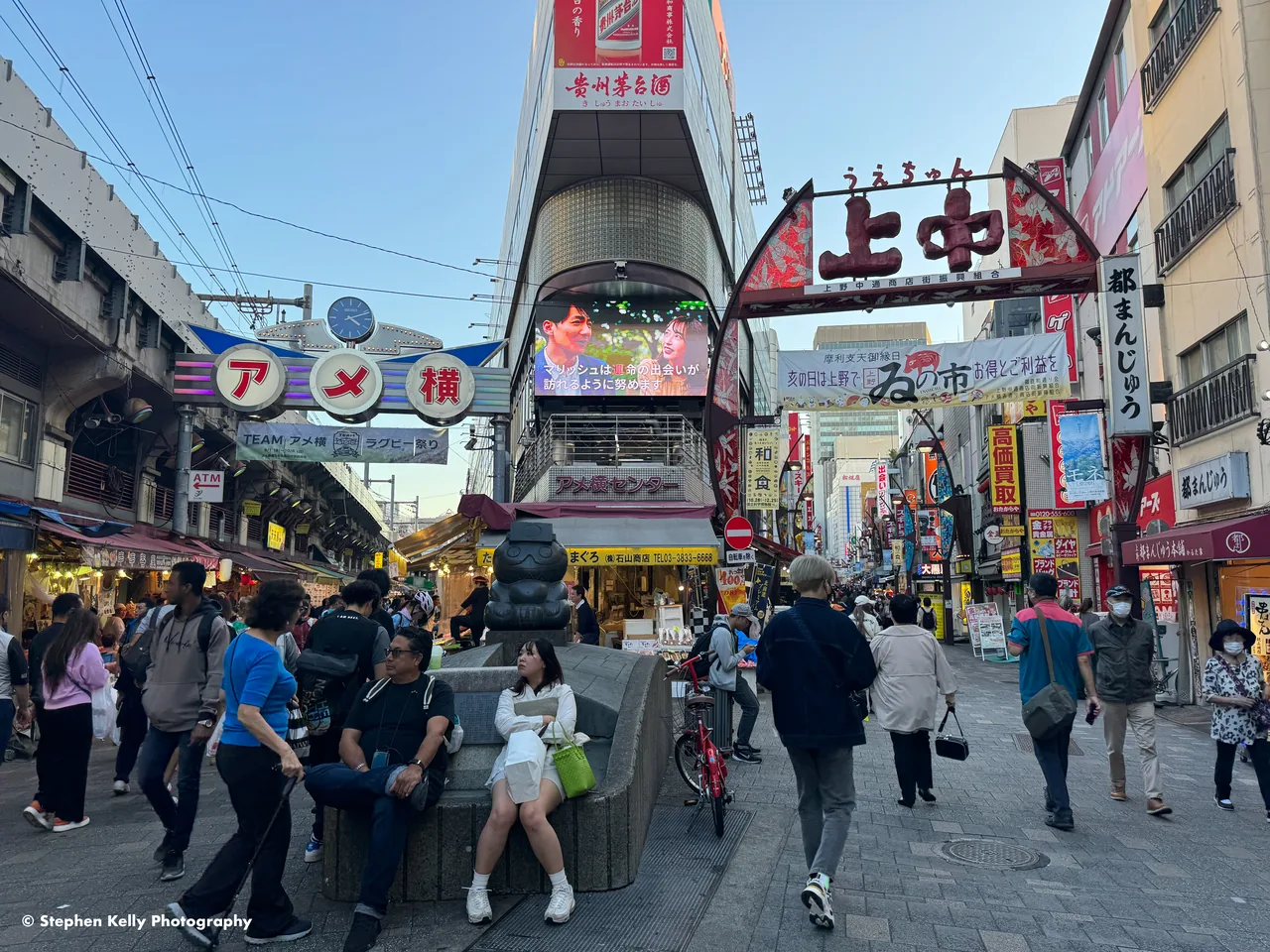 The Ameyoko entrance arch over a crowded shopping lane, shopfronts and signs pressing in on both sides