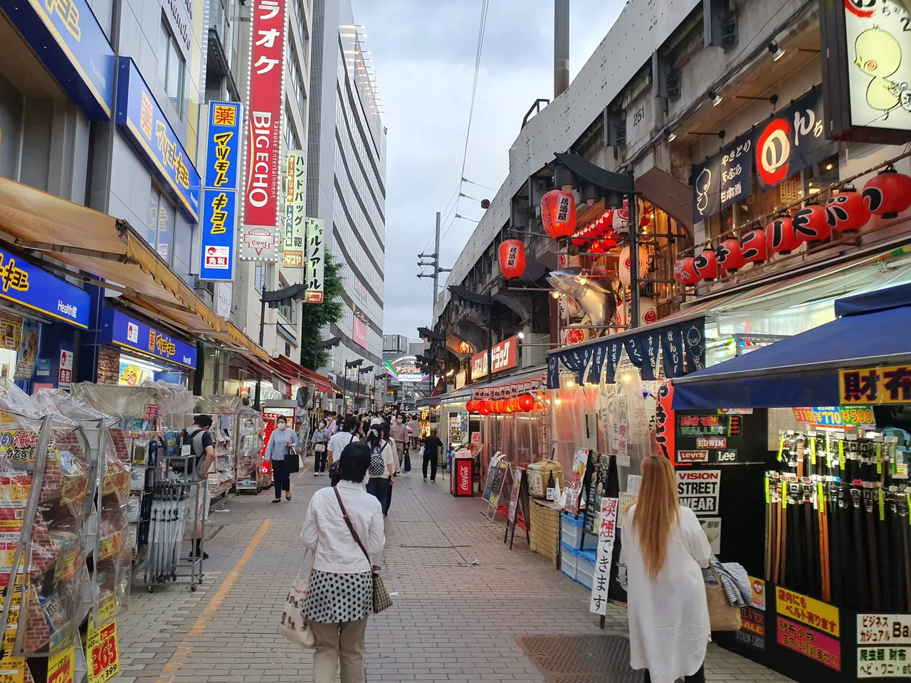 A daytime lane in Ameyoko with goods stacked out onto the pavement in front of the shops