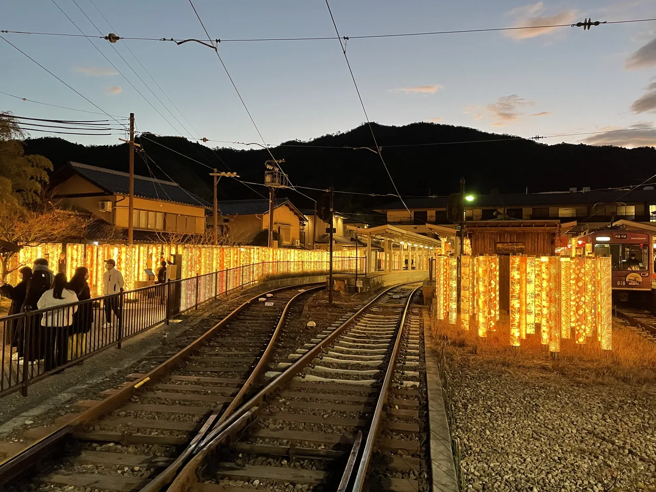 Rows of lit fabric-wrapped pillars on the platform at Randen Arashiyama station