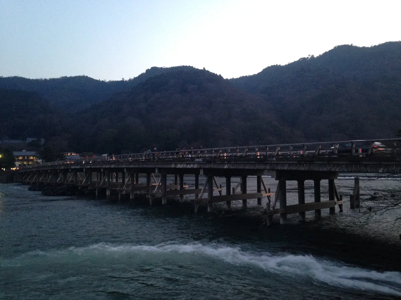 Togetsukyo Bridge crossing the river in Arashiyama with the wooded mountain behind it