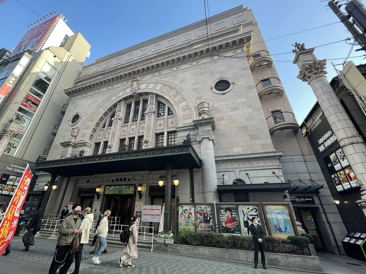 The stone facade of a theatre with a large arch over its entrance