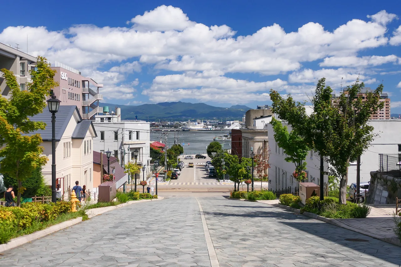A straight cobbled slope running down between buildings to the sea