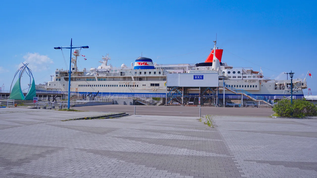 A large white and blue passenger ferry moored at a quay