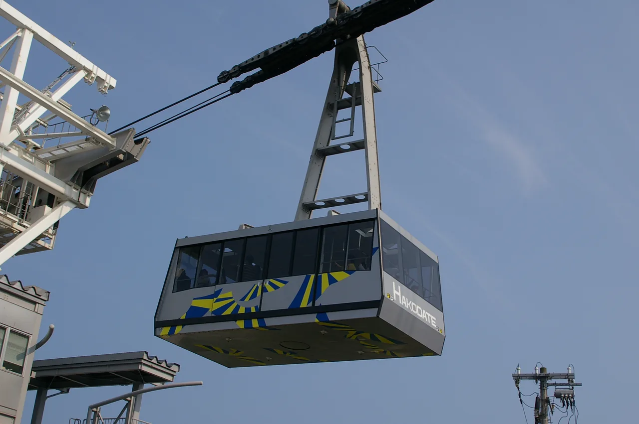 A ropeway gondola hanging from its cable, seen from below