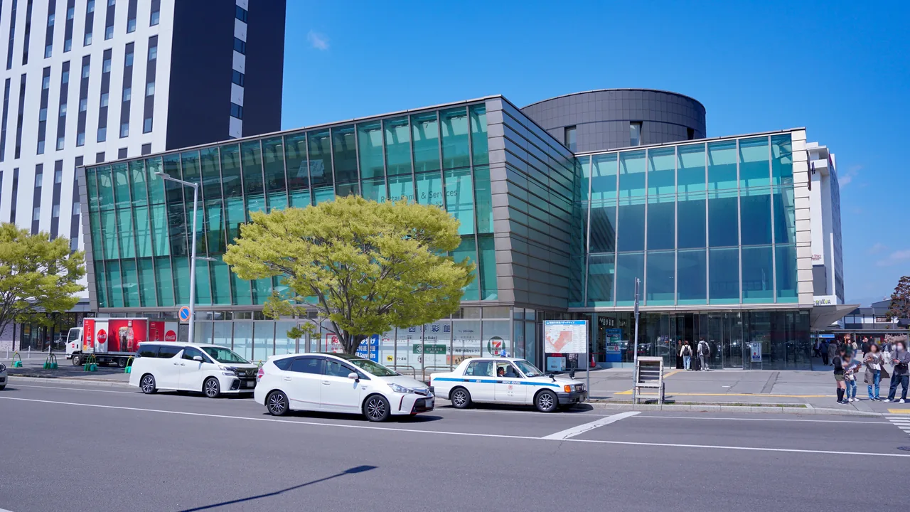 The glass front of Hakodate Station with taxis waiting outside