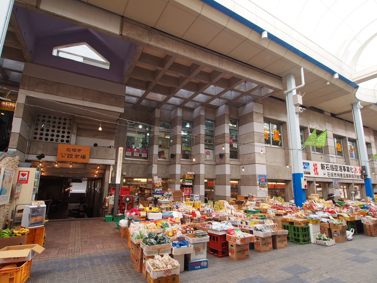 The inside of a covered market hall with stalls of packaged goods