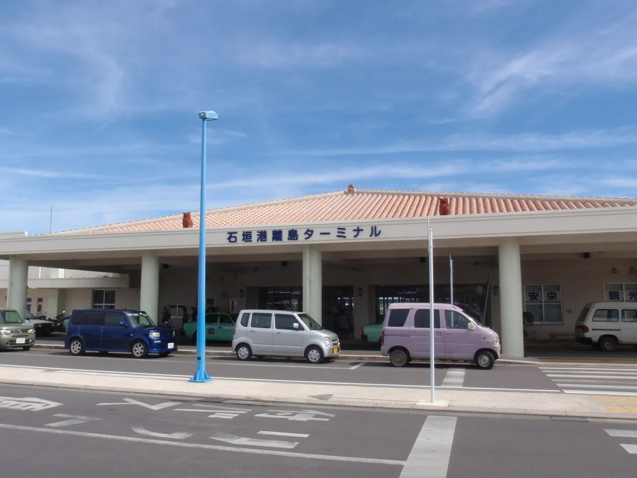 The low front of the Ishigaki port remote island terminal with cars parked outside