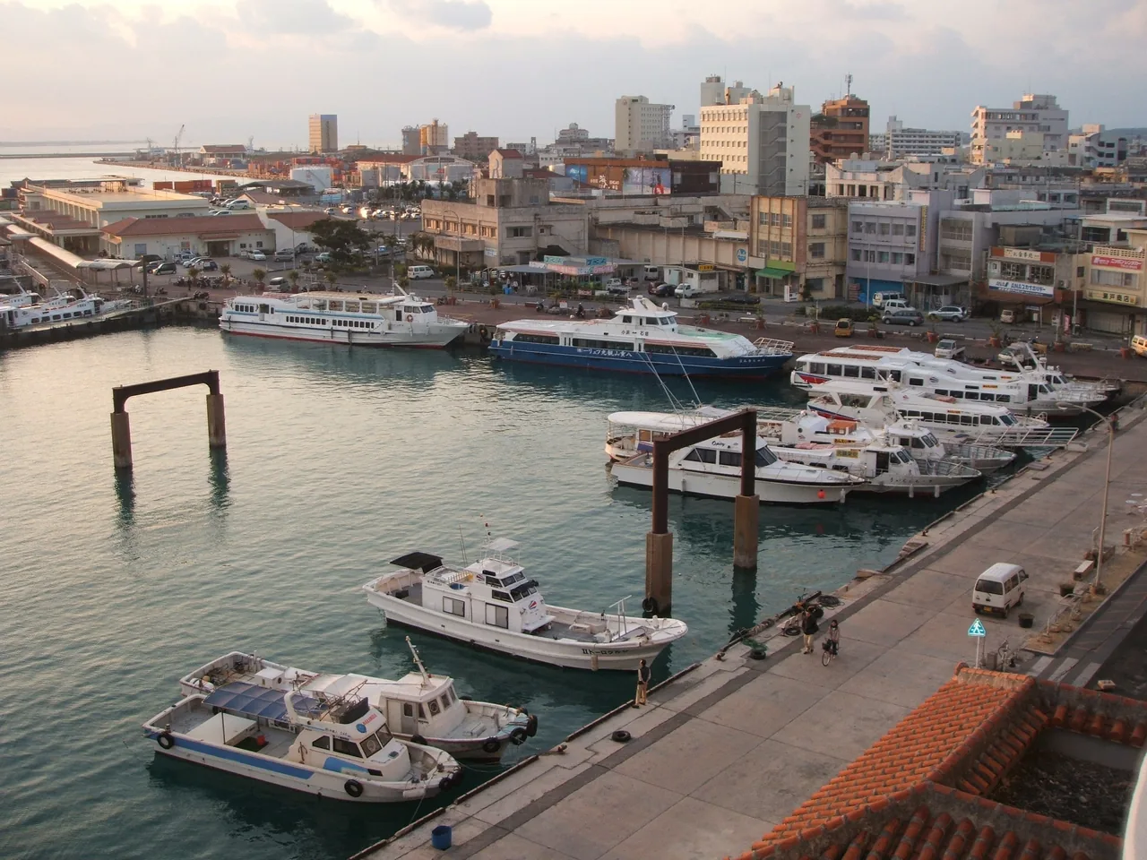 Small boats moored in Ishigaki harbour with low town buildings behind, seen from a hotel window