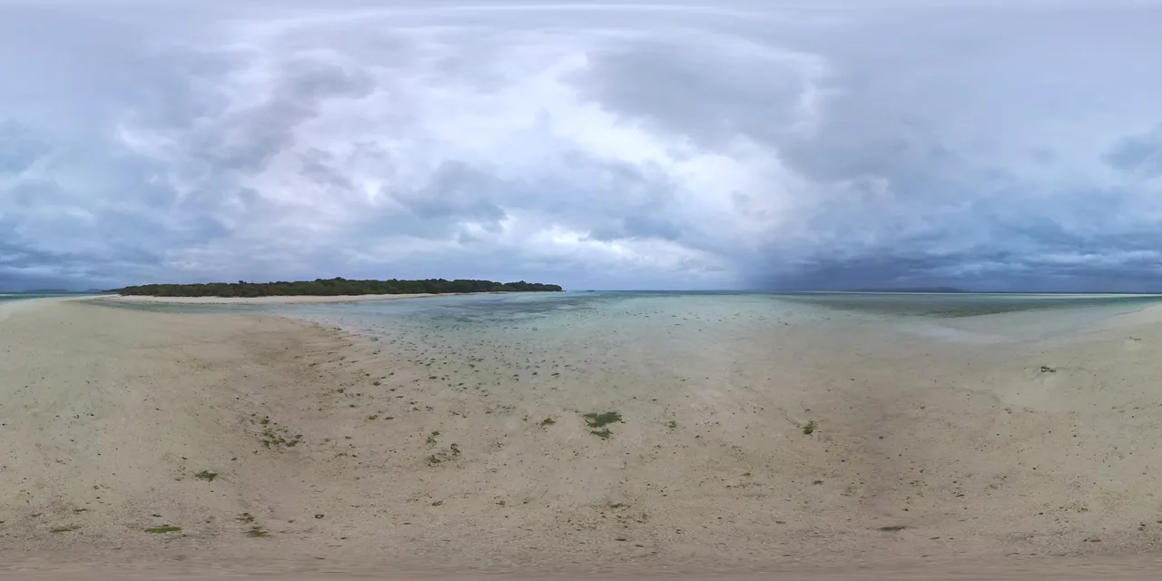 A wide shallow beach on Taketomi with very pale water and no buildings