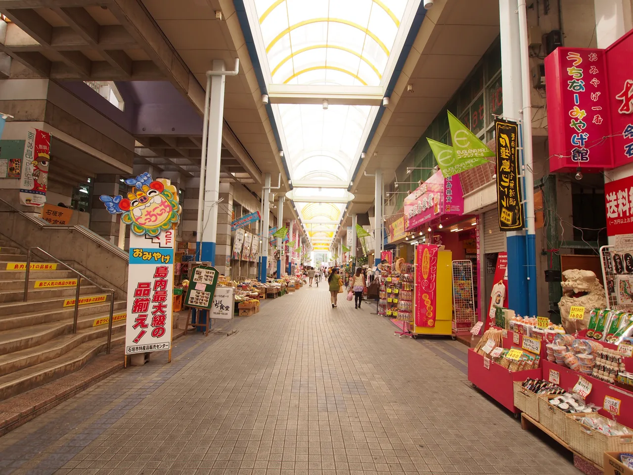 A covered shopping arcade in the town with shopfronts on both sides