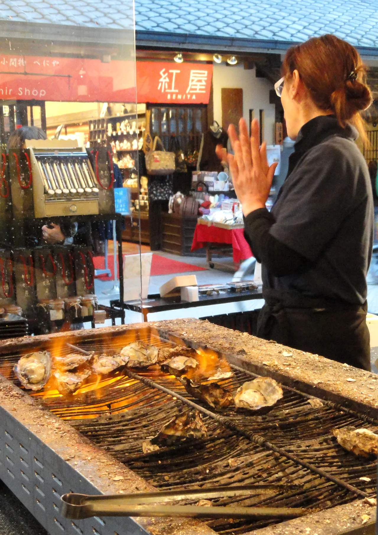 Several oysters grilling on a barbecue grate