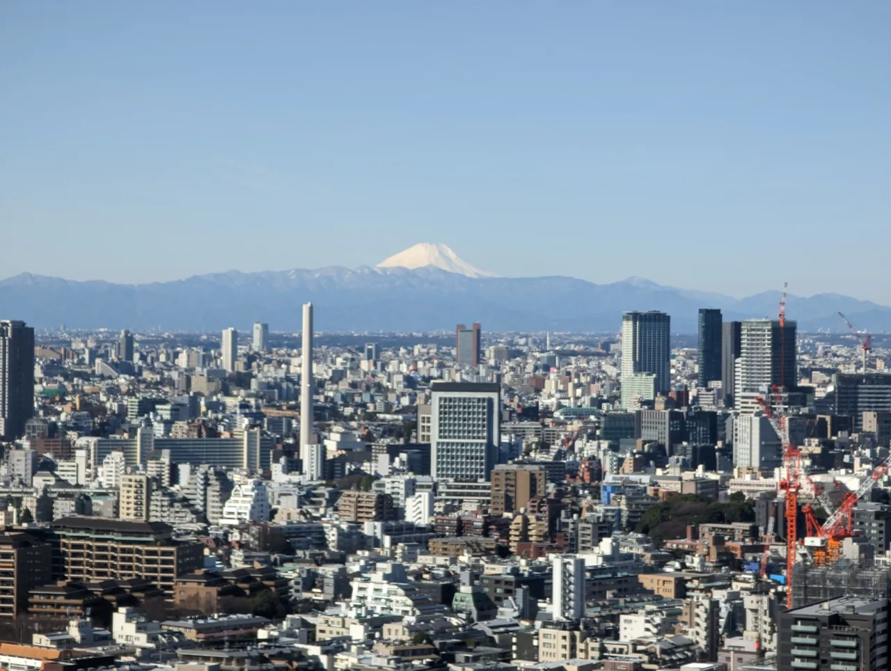 Snow-capped Mt Fuji beyond the Tokyo skyline under a clear winter sky