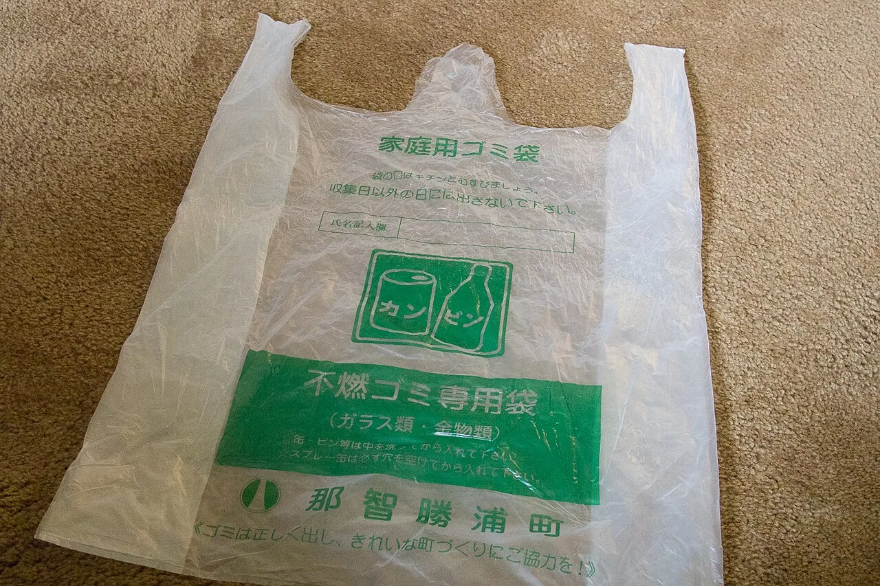A semi-transparent household rubbish bag printed with a municipality's name and a non-burnable label