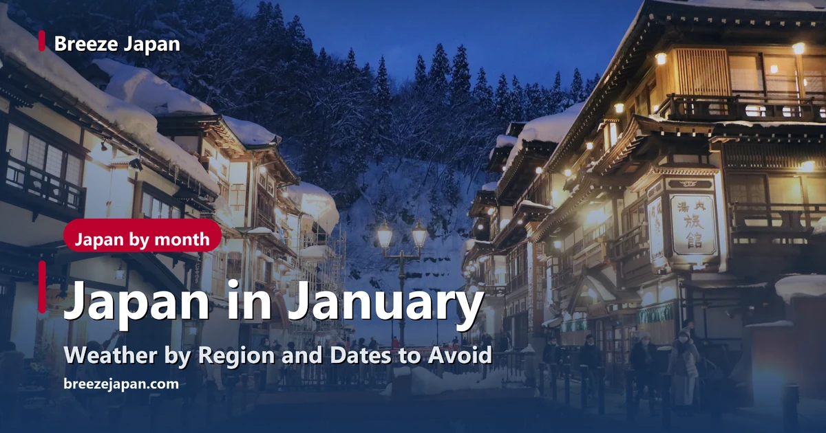 Ginzan Onsen at dusk, snow on the wooden inns lit up along both banks of the river