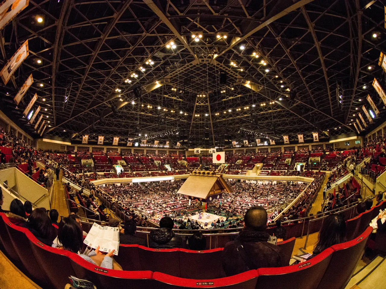 The packed Ryogoku Kokugikan around the ring, with the roof hanging above it