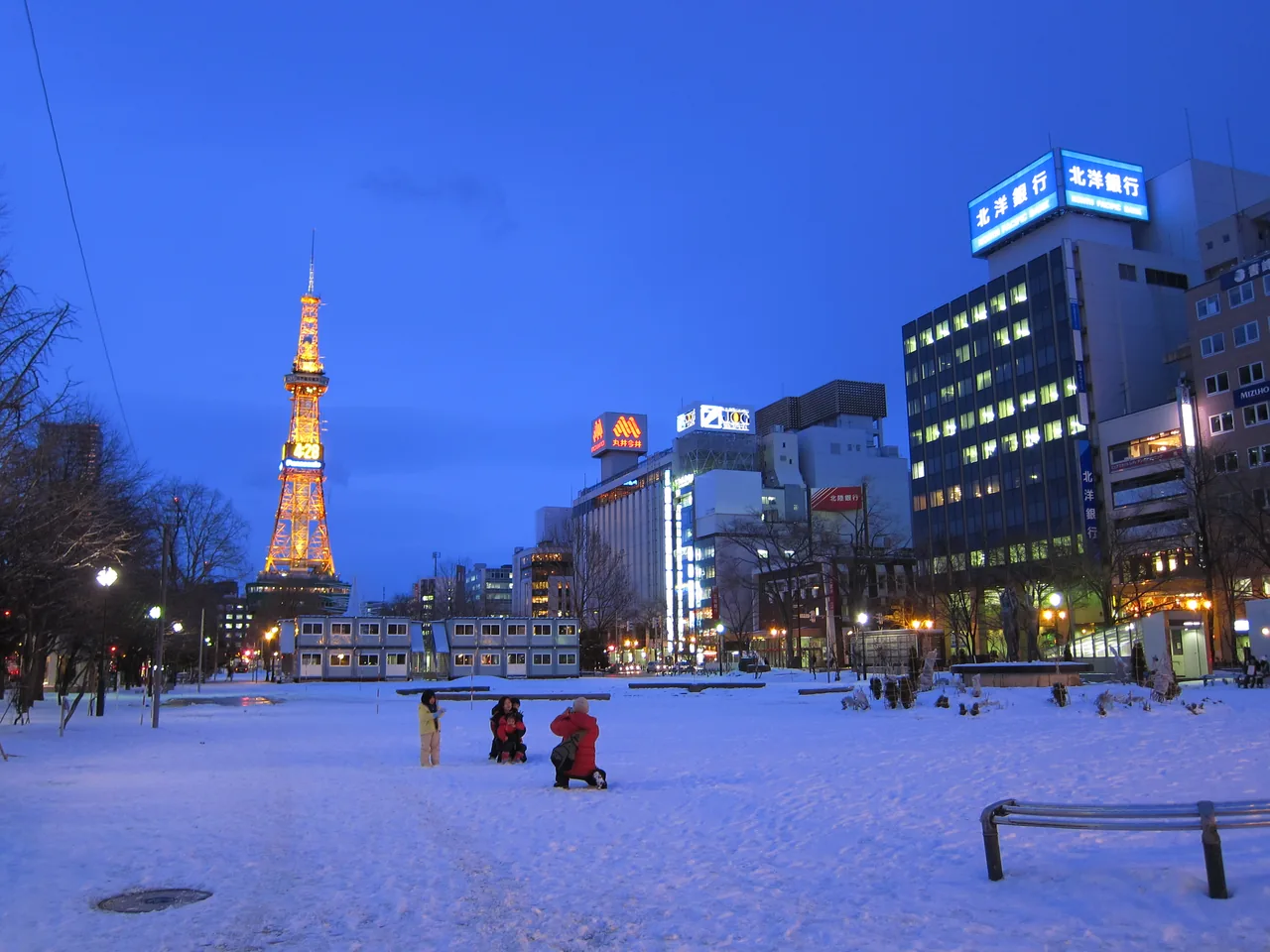 Snow-covered Odori Park at dusk with the lit Sapporo TV Tower